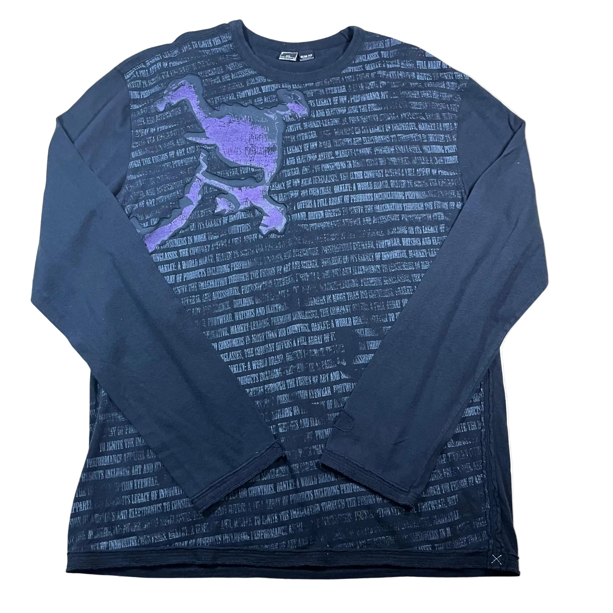 Flat-lay product photo of a vintage Oakley dark navy blue long sleeve shirt featuring a purple abstract tech-goggle graphic on the chest layered over a subtle, dark all-over text background print
